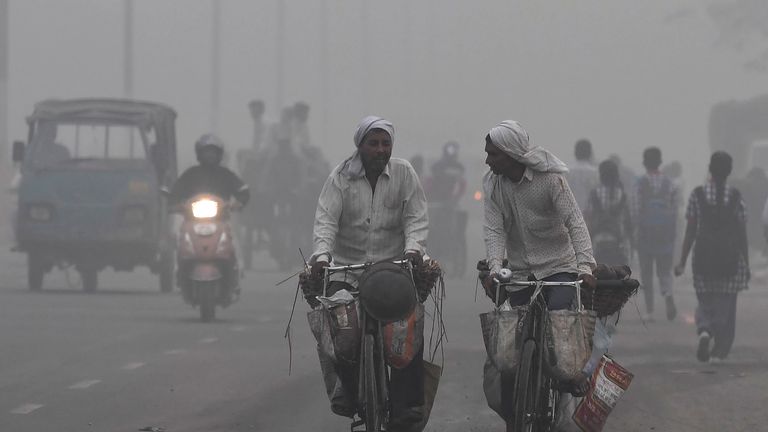 Indian commuters drive amid heavy smog in New Delhi