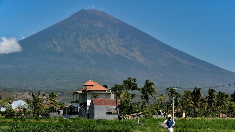 A farmer fertilizers his field at the base of Mount Agung volcano, in Karangasem Regency on the Indonesian resort island of Bali on September 27, 2017. Indonesian authorities are ready to divert flights to and from the holiday island of Bali as increasingly frequent tremors from a rumbling volcano stoke fears an eruption could be imminent. / AFP PHOTO / BAY ISMOYO (Photo credit should read BAY ISMOYO/AFP/Getty Images)