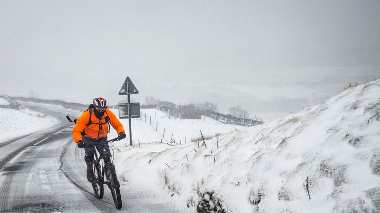 A cyclist on the Buttertubs Pass in the Yorkshire Dales as snow hits the UK in February 2017