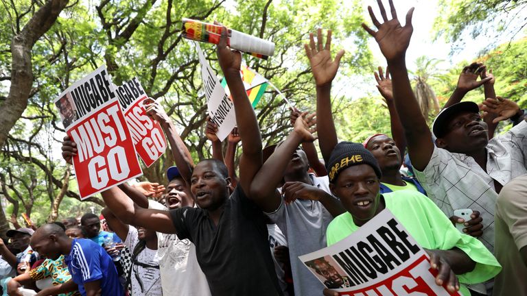 Protesters call for Zimbabwean President Robert Mugabe to resign across the road from parliament in Harare