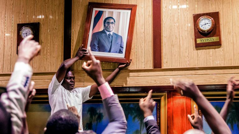 Mugabe&#39;s portrait is removed from a wall in Harare&#39;s International Conference centre