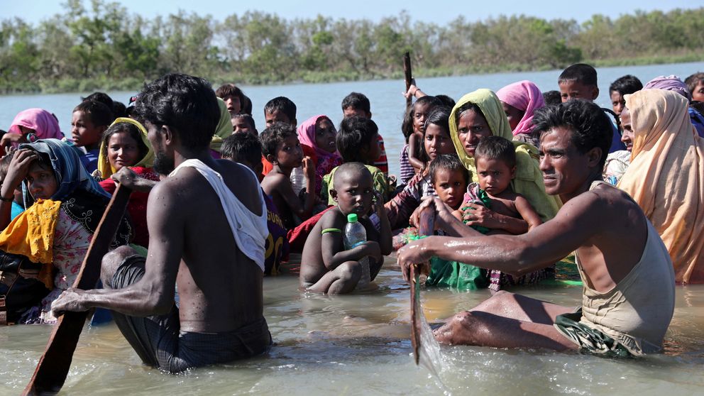 Rohingya refugees cross the Naf river on an improvised raft