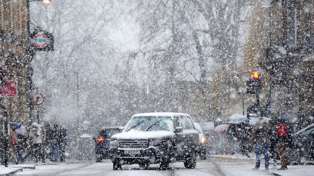 Snow falls on icy UK, causing treacherous conditions and travel warnings