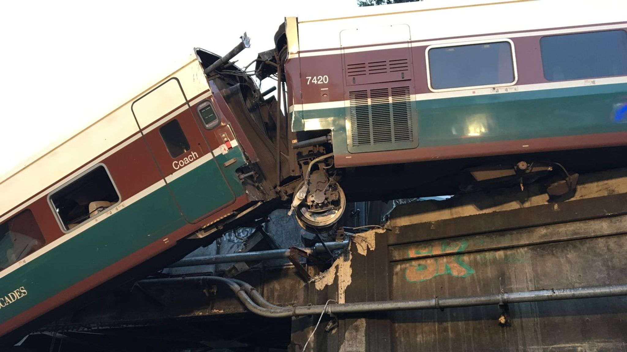 Three die as train derails on highway bridge and hits cars in