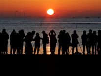 People watch the first sunrise on New Year's Day at a beach in Tokyo, Japan, January 1, 2018