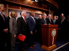 Senate Majority Leader Mitch McConnell, at the podium, at a news conference on the bill