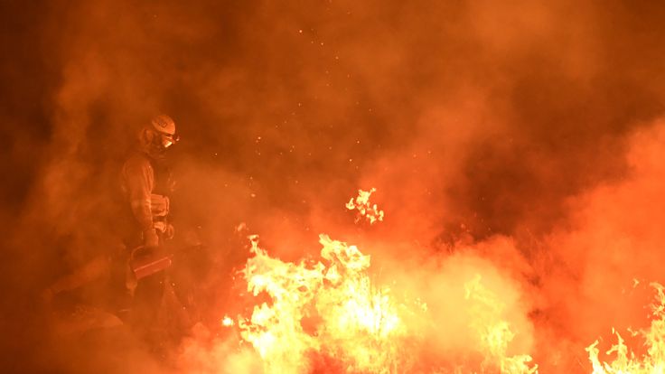 Firefighters light backfires as they try to contain the Thomas wildfire which continues to burn in Ojai, California on December 9, 2017. Brutal winds that fueled southern California&#39;s firestorm finally began to ease Saturday, giving residents and firefighters hope for respite as the destructive toll of multiple blazes came into focus. / AFP PHOTO / MARK RALSTON (Photo credit should read MARK RALSTON/AFP/Getty Images)