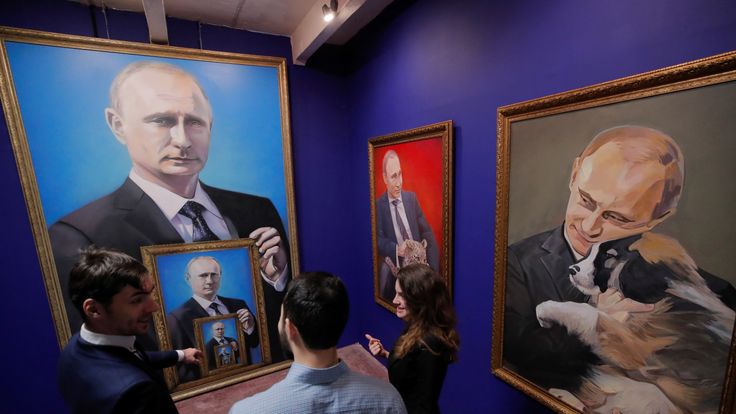 People look at the paintings depicting Russian president Vladimir Putin at the "SUPERPUTIN" exhibition in UMAM museum in Moscow, Russia