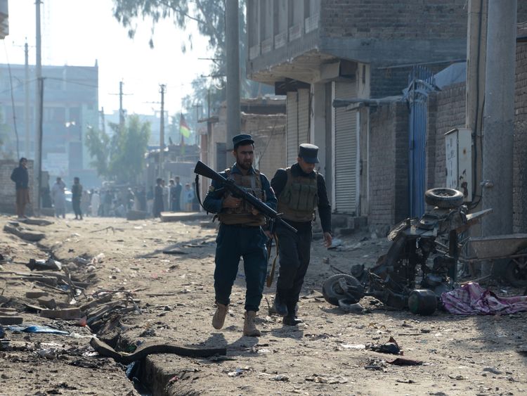 Afghan security force members inspect the site of blast near a TV station in Jalalabad