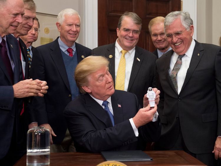 US President Donald Trump holds up an astronaut toy alongside former US Senator and Apollo 17 Astronaut Jack Schmitt 