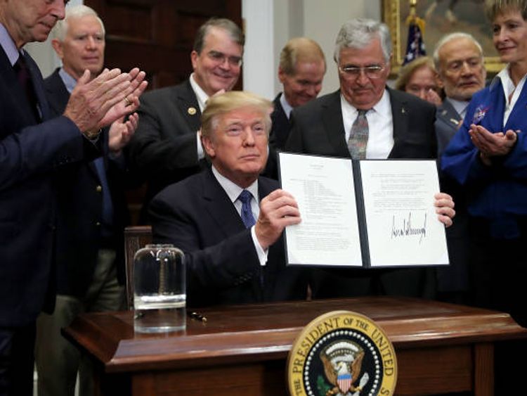 President Donald Trump holds up &#39;Space Policy Directive 1&#39; after signing it during a ceremony with NASA astronauts Peggy Whitson, Buzz Aldrin and Jack Schmitt