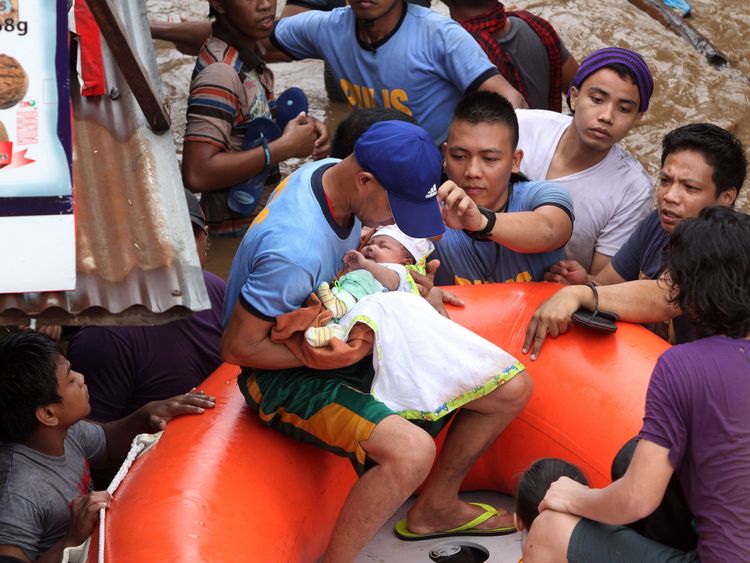 Policemen evacuate a baby in Cagayan City