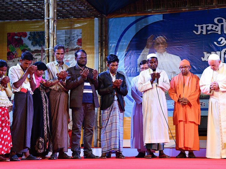 Pope Francis (R) prays next to Rohingya refugees during an interreligious meeting in Dhaka on December 1, 2017