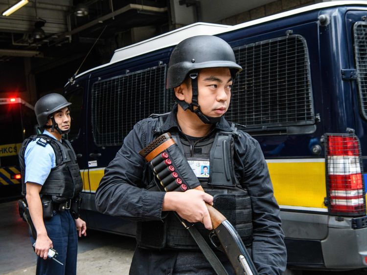 Armed police stand guard as Rurik Jutting arrives at a courthouse