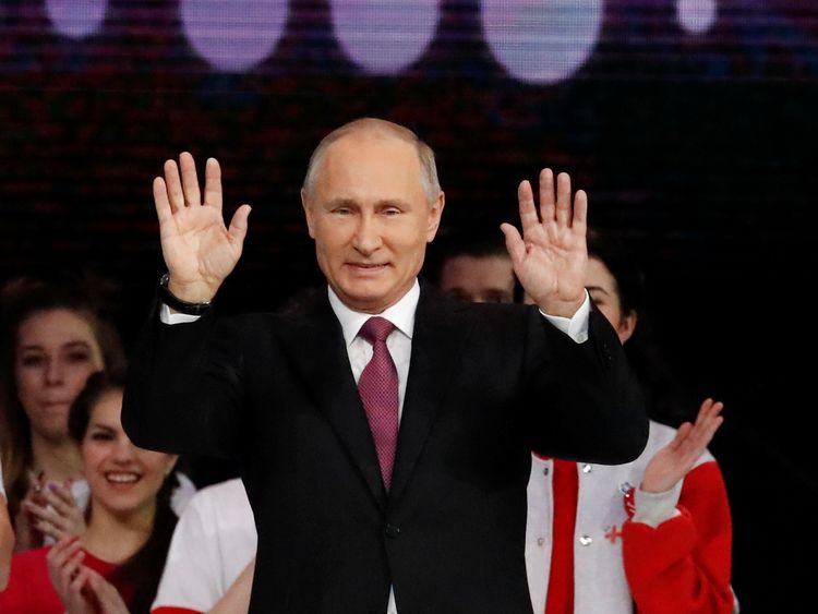 Russian President Vladimir Putin greets the audience at the congress of volunteers in Moscow