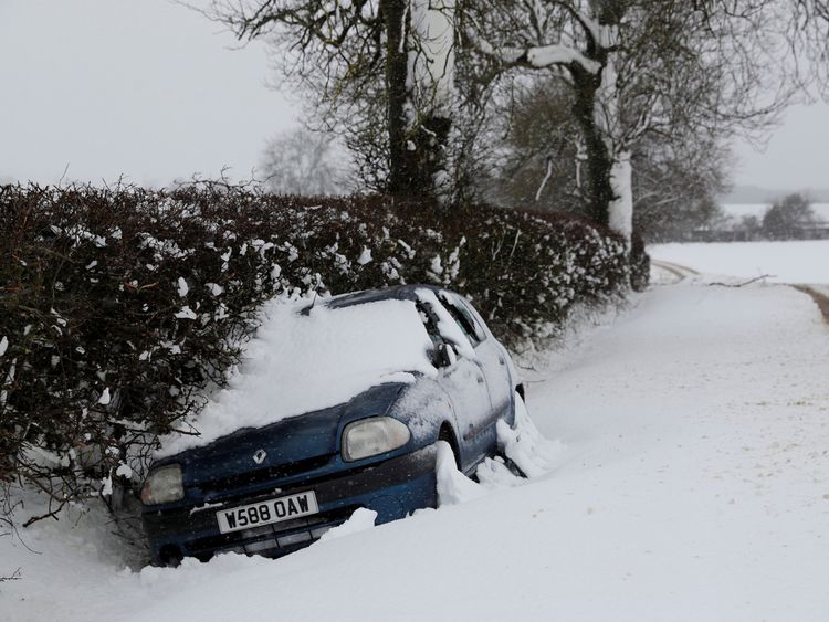 A stranded car lies in a ditch after snow fall in Stanford on Avon