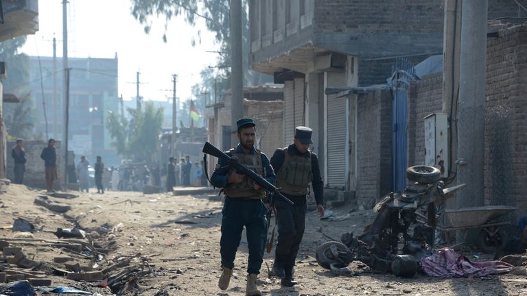 Afghan security force members inspect the site of blast near a TV station in Jalalabad