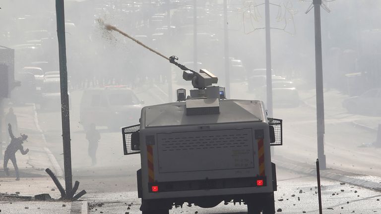 Israeli troops fire a water canon towards Palestinian protesters during clashes in Bethlehem