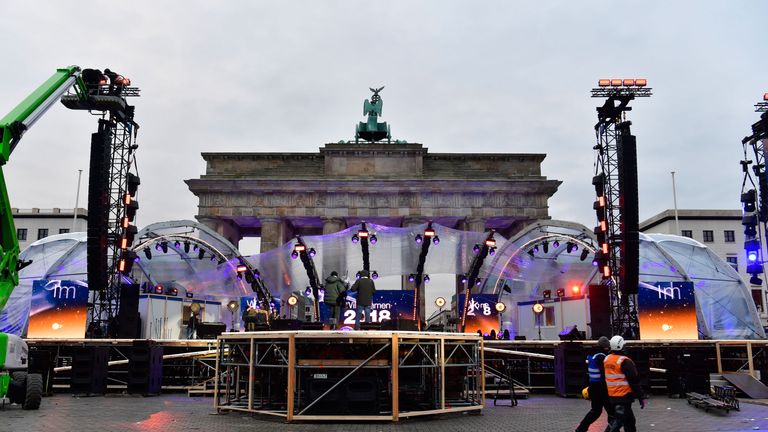 People prepare the stage for New Year&#39;s Eve festivities in front of Berlin&#39;s landmark Brandenburg Gate on December 30, 2017. / AFP PHOTO / John MACDOUGALL (Photo credit should read JOHN MACDOUGALL/AFP/Getty Images)