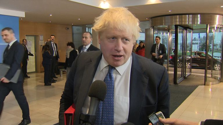 Boris Johnson talking to media in building lobby.