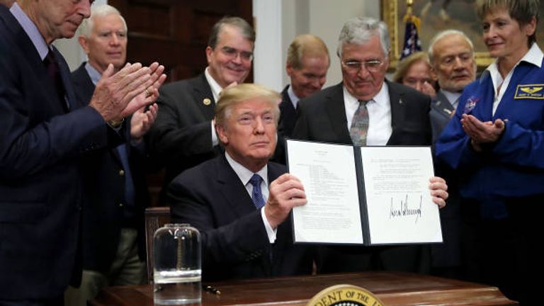 President Donald Trump holds up &#39;Space Policy Directive 1&#39; after signing it during a ceremony with NASA astronauts Peggy Whitson, Buzz Aldrin and Jack Schmitt