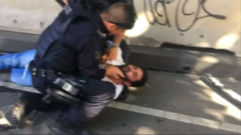 Police try to rouse the arrested man, who appears to be unconscious