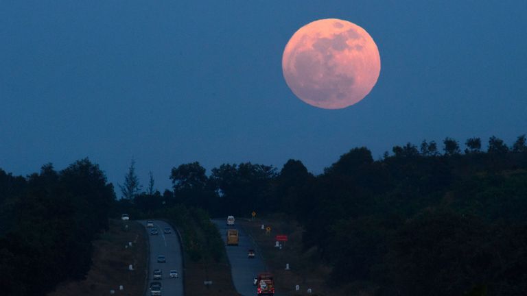 The supermoon rises over a highway near Yangon on December 3, 2017. The lunar phenomenon occurs when a full moon is at its closest point to earth