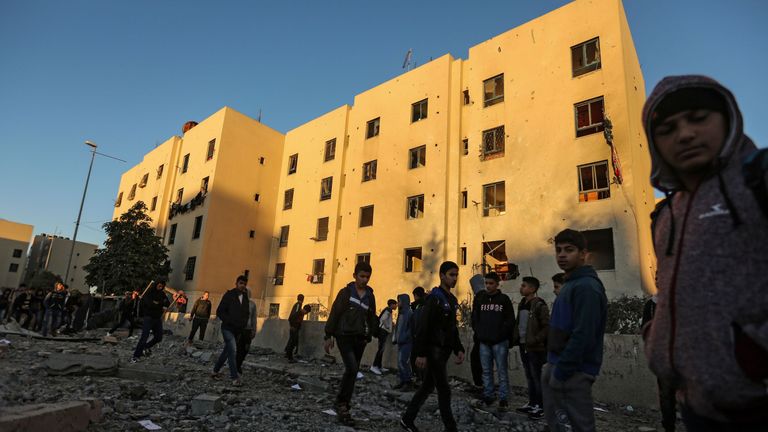 Palestinians look at the damage in the aftermath of an Israeli air strike in Beit Lahia