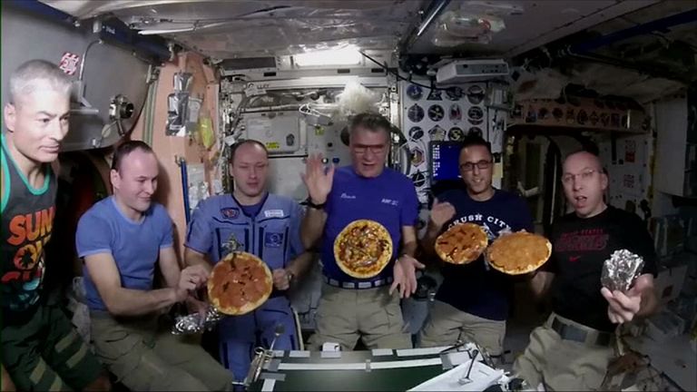 The astronauts with their pizzas in space