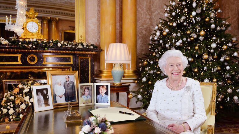Queen Elizabeth sits at a desk in the 1844 Room at Buckingham Palace