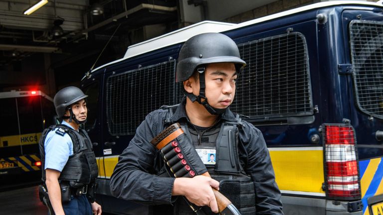 Armed police stand guard as Jutting arrives at a courthouse