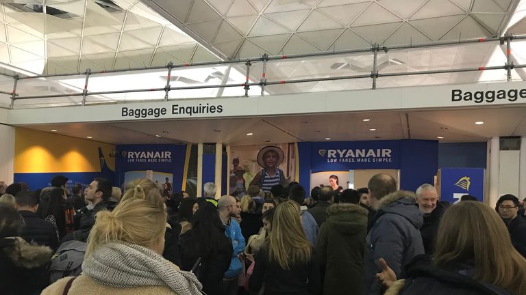 Passengers wait for information at Stansted Airport. Pic: Sophia Sleigh