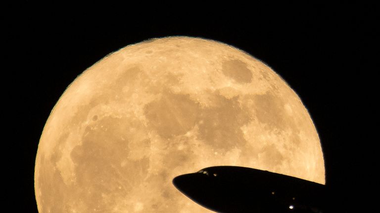 An aircraft taking off from Ronald Reagan National Airport is seen passing in front of the Moon as it rises, Sunday, Dec. 3, 2017 in Washington.  Today&#39;s full Moon is the first of three consecutive supermoons. The two will occur on Jan. 1 and Jan. 31, 2018. A supermoon occurs when the moon...s orbit is closest (perigee) to Earth at the same time it is full. Photo Credit: (NASA/Bill Ingalls)
