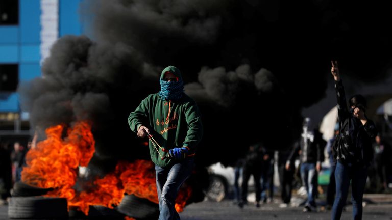 A Palestinian protester runs during clashes with Israeli troops 