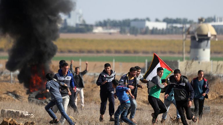 Palestinian protesters run during clashes in the southern Gaza Strip