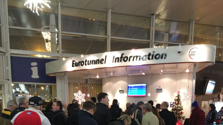 Travellers queue at an information desk amid delays at the Eurotunnel terminal in Calais