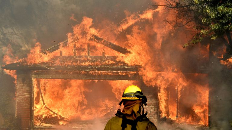 Firefighters battle to save one of many homes burning