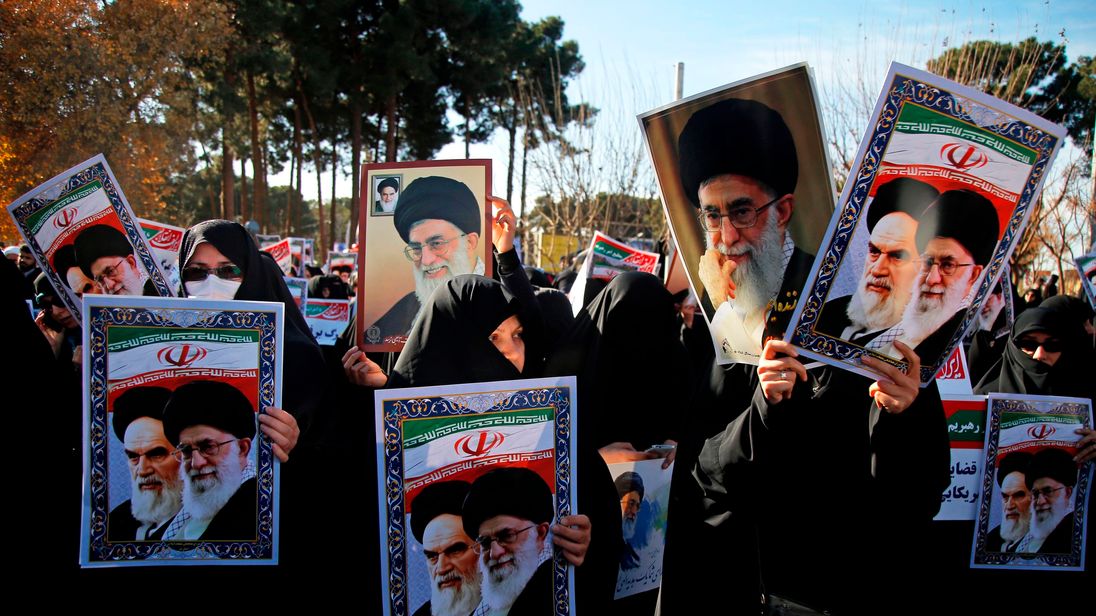 Counter-protesters holding posters of Ayatollah Ali Khamenei and Ayatollah Ruhollah Khomeini
