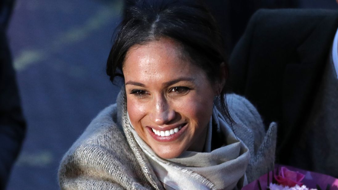 Meghan Markle receives a bouquet of flowers from a fan in Brixton