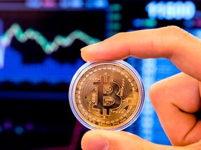 An Israeli holds a visual representation of the digital cryptocurrency Bitcoin, at the &#39;Bitcoin Change&#39; shop in the Israeli city of Tel Aviv on January 17, 2018. At the end of 2017 Israel Securities Authority said it was moving to ban trading in cryptocurrency-based companies on the Tel Aviv market until transactions involving digital coins are legally regulated. / AFP PHOTO / JACK GUEZ (Photo credit should read JACK GUEZ/AFP/Getty Images)
