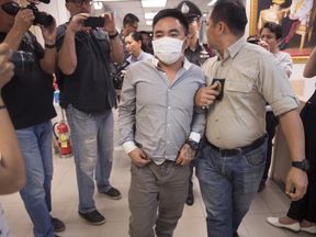 Boonchai Bach (C), 40, a Vietnamese national with Thai citizenship and alleged kingpin in Asia&#39;s illegal trade in endangered species, is escorted past journalists as he is processed at a police station in Bangkok on January 20, 2018