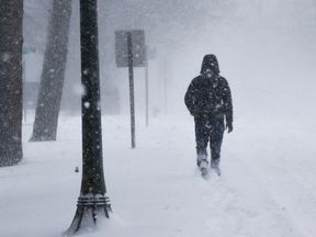 A man struggles against wind and snow in Monmouth Beach, New Jersey