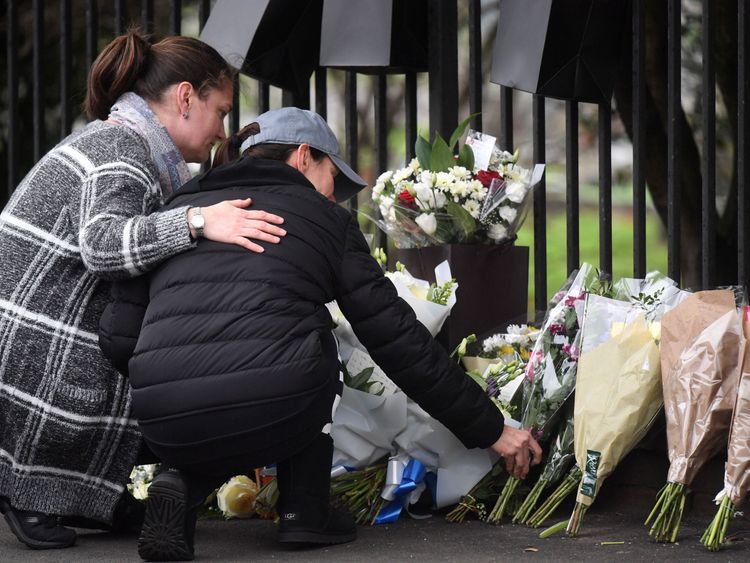 People leave flowers at the scene