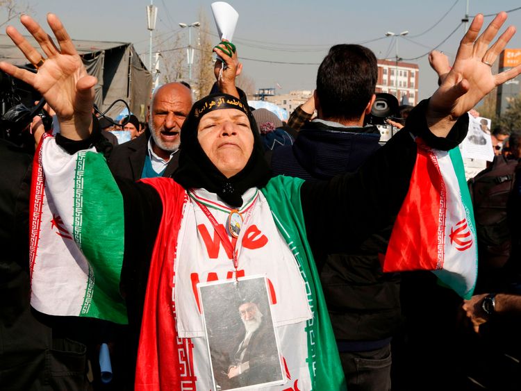 A woman wears a portrait of Supreme leader Ayatollah Ali Khamenei during a pro-government march in Iran  