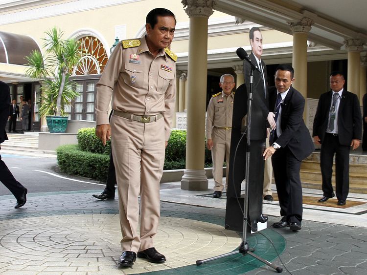 Thailand&#39;s Prime Minster Prayuth Chan-ocha speaks to reporters next to a cardboard cut-out of himself
