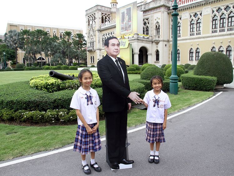 Children pose next to a cardboard cut-out of Thailand&#39;s Prime Minster Prayuth Chan-ocha