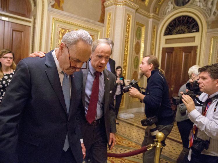 Senate Minority Leader Chuck Schumer (L) and Senator Tom Carper (R) walk out of a Democratic Caucus meeting at the US Capitol 