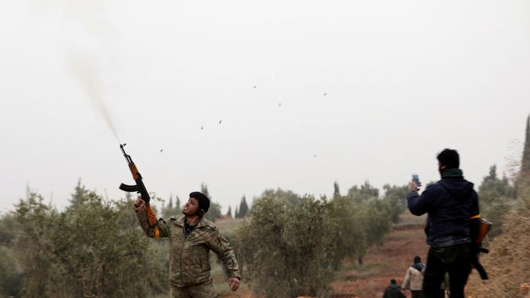 A free Syrian Army fighter shoots his gun near Mount Barsaya, northeast of Afrin