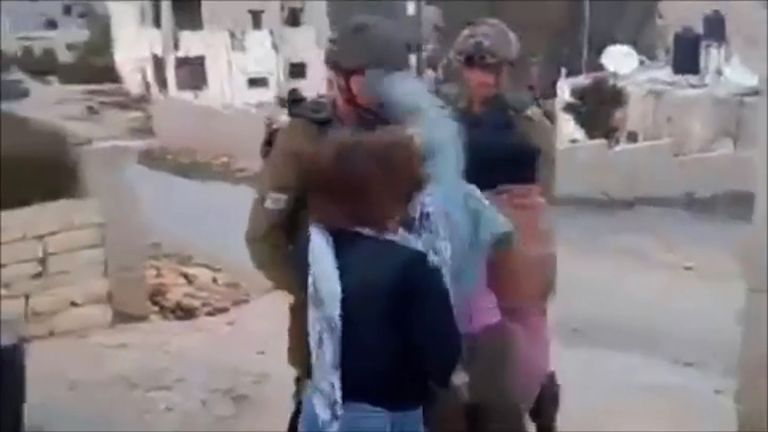 She appears to hit a second soldier in the face in the video