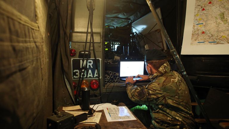 BRECON, PAYS DE GALLES - 16 OCTOBRE: Un soldat suit sur un ordinateur portable des élèves-officiers de l'armée britannique de la Royal Military Academy Sandhurst, alors qu'ils participent à l'exercice Long Reach dans les Brecon Beacons le 16 octobre 2013 près de Brecon, au Pays de Galles.  La marche de 36 heures et 50 miles avec kit, implique 200 cadets, six semaines après le début de leur cours d'un an, étant également amenés à effectuer un certain nombre de tâches de commandement, testant non seulement leur endurance physique mais aussi leur capacité mentale lorsqu'il est fatigué et sous pression. 